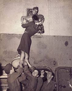 an old black and white photo of people doing tricks on a woman's head