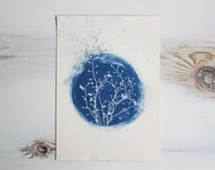 a blue and white painting sitting on top of a wooden table