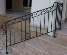 a wrought iron stair railing on the outside of a house