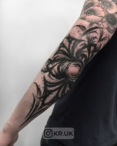 a man with a black and white tattoo on his arm is holding onto a flower