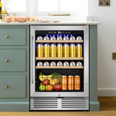 an open refrigerator filled with drinks next to a counter top oven and cabinets in a kitchen