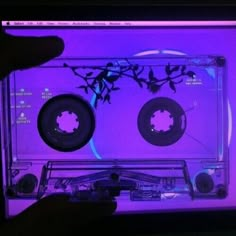 a person is holding up a cd in front of a computer screen with two discs on it