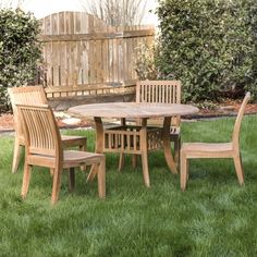 a wooden table and chairs sitting in the grass