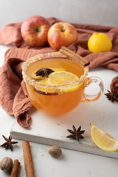 an apple cider is garnished with cinnamon, star anise and lemon slices