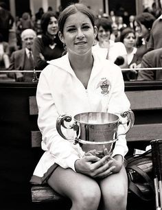 a woman sitting on a bench holding a trophy