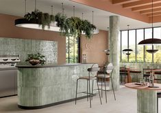 an empty restaurant with tables, chairs and plants hanging from the ceiling over the bar