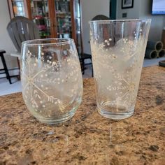 two clear glasses sitting on top of a counter