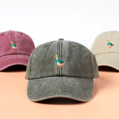 three hats with embroidered ducks on them