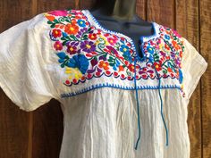 An ethnic, summer festive blouse that is embellished with floral embroidery. Short sleeves. No tags - estimated szie Large - please see measurements. Slightly sheer. Good vintage condition.   Measurements taken across front laid flat Bust17" Shoulder to hem25" Waist24" Festival Embroidered Neckline Top With Short Sleeves, Festival Short Sleeve Top With Embroidered Neckline, Folk Style Embroidered Peasant Top For Summer, Festival Embroidered Top With Short Sleeves, Folk Style Embroidered Short Sleeve Top For Festival, Multicolor Embroidery Blouse For Summer Fiesta, Bohemian Embroidered Fitted Top For Festivals, Multicolor Embroidered Blouse For Summer Fiesta, Traditional Summer Tops For Festive Occasions