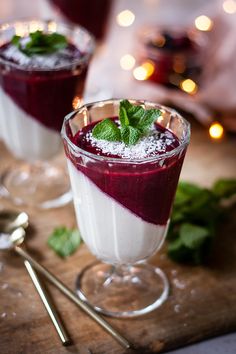 two glasses filled with food on top of a wooden table