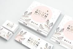 the golden moon business card is shown on a white surface with gold leaves and dots