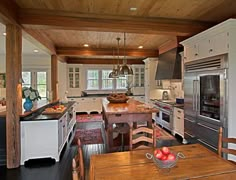 a large kitchen with an island in the middle and lots of wood on the walls