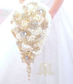 the bride's bouquet is made up of white roses and gold brooches