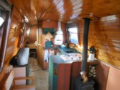 the inside of a small kitchen with wood paneling on the walls and ceiling, along with a stove top oven