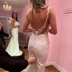 a woman in a wedding dress getting ready to go into her bridal gown for the ceremony