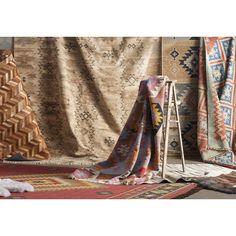 a cat laying on the floor in front of some rugs and other decorative items