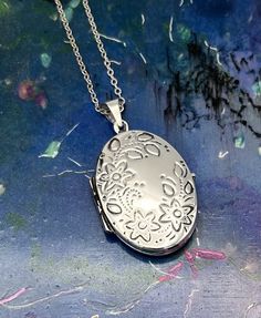 Vintage large oval locket with etched floral design and additional sterling silver chain  ( optional ) in varies lengths ( see options at check out ). This striking locket has a mid century classic etched floral design on the front and plain reverse which is stamped 925 ( 925 is the stamp for sterling silver).  The clasp opens and shuts perfectly. The pendant comes in a decorative pouch with matching ribbon bow. Description - Lenght locket - 3.5 cm  Width locket - 2.4 cm  Weight ( locket only ) - 5.4 grams  Box not included in purchase just for presentation purposes.  All items are packed safely packed in bubble wrap, brown craft paper and packed in boxes with extra protection compostable packing pellets.. All items are sent by registered tracked delivery. Thanks for looking Sterling Silver Oval Locket Necklace, Nickel-free, Nickel-free Oval Locket Necklace As Gift, Oval Nickel-free Locket Necklace As Gift, Oval Sterling Silver Locket Necklace Nickel Free, Oval Sterling Silver Nickel-free Locket Necklace, Spiritual Silver Oval Pendant Locket Necklace, Silver Oval Locket Necklace Nickel-free, Silver Oval Link Locket Necklace Keepsake, Silver Oval Locket Necklace Nickel Free