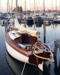 a sailboat docked at a dock with other boats in the background