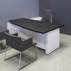 an office desk with two chairs and a black marble top on the floor in front of a gray wall