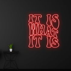 a neon sign that says it's what it is in front of a black wall