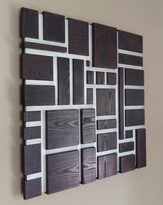 a wooden wall hanging on the side of a wall with squares and rectangles