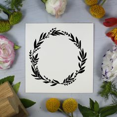 a paper with a wreath on it surrounded by flowers