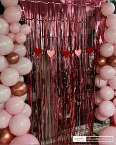 balloons and streamers are arranged in the shape of heart - shaped hearts on display