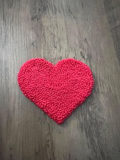 a pink heart shaped rug sitting on top of a wooden floor