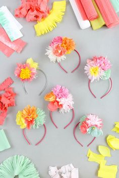 paper flowers and other crafting supplies laid out on top of a gray surface,