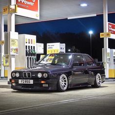 a black car parked in front of a gas station