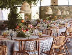 an outdoor dining area with tables and chairs set up for a party or function, surrounded by greenery