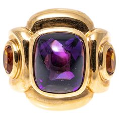 14k yellow gold ring. This impactful ring has a rectangular sugarloaf cabochon cut dark purple color amethyst center, bezel set and flanked by two oval faceted, dark orange color citrines, approximately 0.18 TCW, also bezel into a chunky, contemporary rectangular profile mounting. Marks: 14k Dimensions: 13/16" across the top x 11/16" wide Weight: 9.3 gross dwt Ring Size: 6.5 Dark Orange Color, Amethyst Cocktail Ring, Yellow Gold Cocktail Ring, Dark Purple Color, Amethyst And Citrine, Amethyst And Diamond Ring, Gold Cocktail Ring, Citrine Ring, Modern Ring