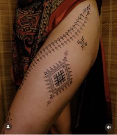 a woman with a tattoo on her leg that has letters and numbers written in it