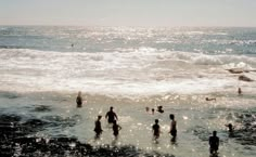 many people are in the water at the beach