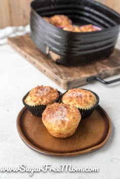 three muffins sitting on a plate next to an iron skillet filled with food