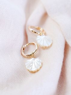 The Lanikai Hoops reflect Hawaii's natural abundance and beauty. These small gold mother of pearl and gold huggie hoop earrings feature darling carved seashell charms. These pretty gold hoops are perfect solo or teamed with our other mini hoops. Handmade on Maui, Hawaii. ✦ DETAILS ✦ ✧ Name: Lanikai (LAH nee kaee) - heavenly ocean. ✧ 18kt Gold Filled. ✧ 27mm total length and a 13mm hoop diameter and 2mm hoop thickness. ✧ All Ke Aloha Jewelry pieces come packaged thoughtfully, beautifully, and rea Shell Pearl Earrings, Shell-shaped Pearl Charm Earrings As Gift, Gold Mother Of Pearl Shell-shaped Earrings, Elegant Shell-shaped Gold Hoop Earrings, Nickel-free Gold Mother Of Pearl Jewelry, Elegant Gold Shell Hoop Earrings, Single Gold Earring With Mother Of Pearl, Gold Shell-shaped Hoop Earrings, Gold Shell-shaped Hoop Earrings For Pierced Ears