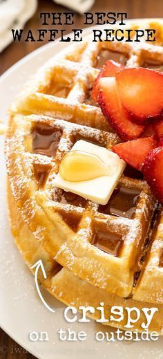 a waffle with syrup, butter and strawberries on the side that says crispy on the outside