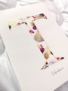 the letter f is made up of watercolors and paper with flowers on it