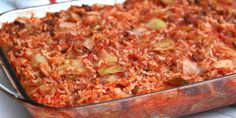 a casserole dish with meat and vegetables in it sitting on a counter top