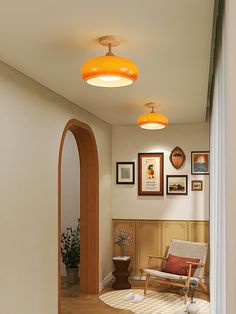 an arched doorway leads to a living room with pictures on the wall and a chair