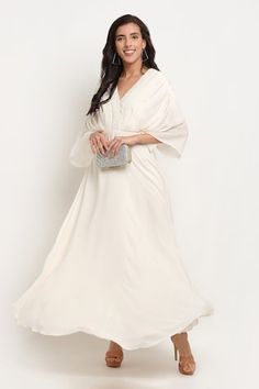 White gown featuring a V-neckline and kimono sleeves, Fit: Relaxed White Embroidered Gown With Traditional Drape, Silk V-neck Dress For Reception, White Hand Embellished Gown Traditional Drape, Elegant V-neck Gown For Reception, White Pearl Embroidery Kaftan, Pearl Embroidered V-neck Wedding Dresses, White V-neck Embellished Kaftan, Embroidered Cotton V-neck Kaftan, Drape Gowns