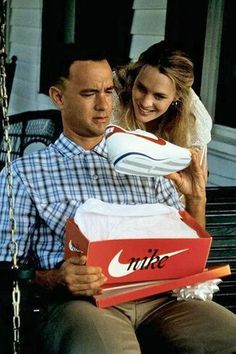 a man and woman sitting on a porch swing with nike shoes in front of them