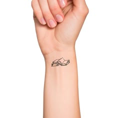 a woman's arm with a book tattoo on the left side of her wrist