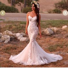 a woman in a wedding dress standing on the side of a road wearing a flower crown