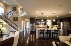 a large open floor plan living room and kitchen area with stairs leading up to the second story