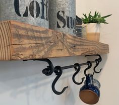 a wooden shelf with two mugs hanging from it's hooks on the wall