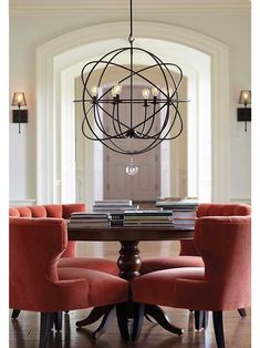 a dining room table with chairs around it and a chandelier hanging from the ceiling