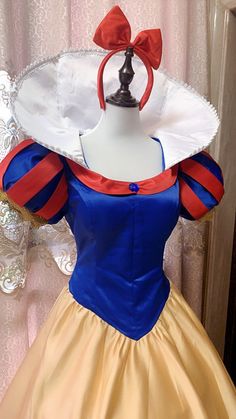 a dress made to look like snow white with a red bow on the top and yellow skirt