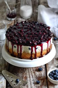 a blueberry cheesecake on a white cake plate