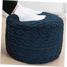 a person with white socks on top of a blue bean bag chair in a living room